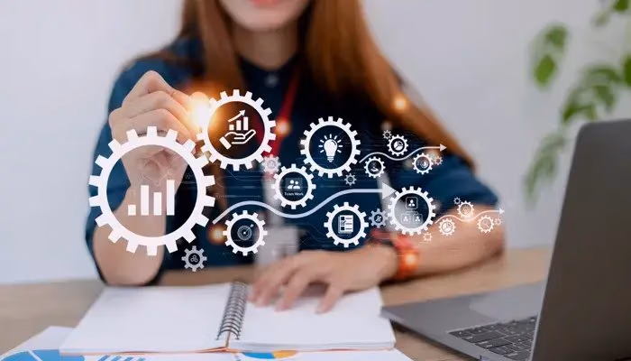 A person interacting with virtual gears and icons representing various benefits of a Quality Management System (QMS).