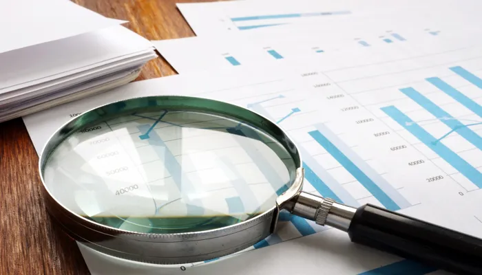 Internal audit: magnifying glass used to examine audit documents