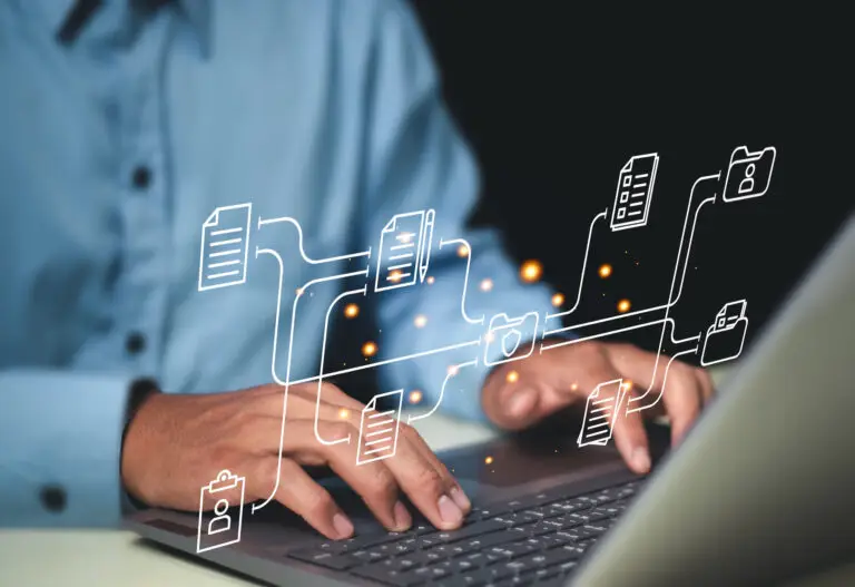 A person typing on a laptop with virtual icons of documents and folders, representing enterprise asset management.