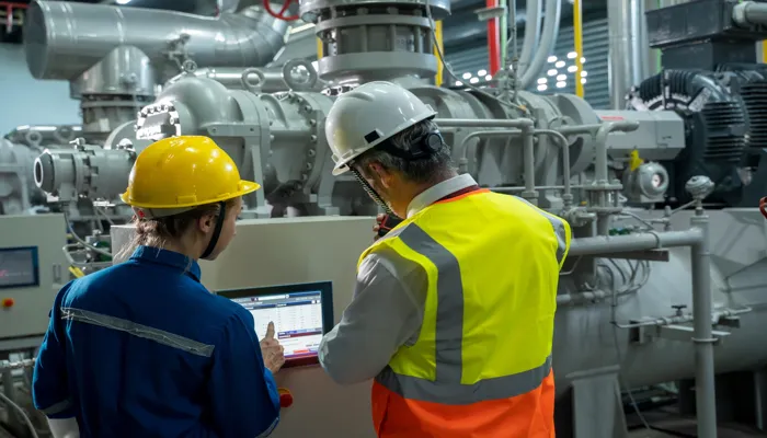 Workers conducting maintenance inspection on industrial equipment.