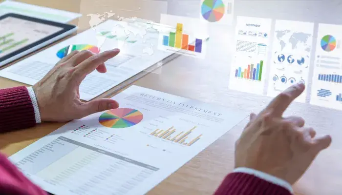 A person analyzing various charts and graphs on a tablet and paper documents related to operational risk management.