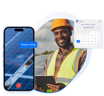 A smiling energy technician in a hard hat stands beside solar panels, with a smartphone showing a broken panel alert and a Flowdit calendar for task management.