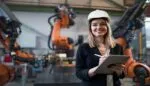 Change management in manufacturing: professional overseeing robotic processes with tablet