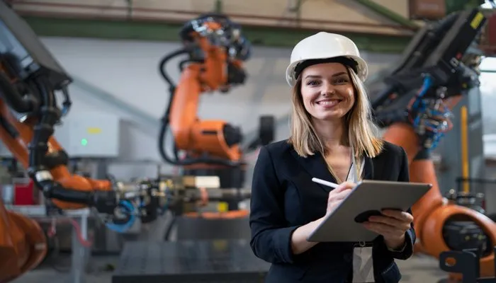 Change management in manufacturing: professional overseeing robotic processes with tablet