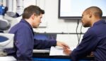 CMMS Training session in progress with two technicians discussing maintenance procedures