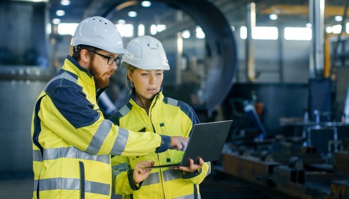 Workers using EHS Management Software to enhance safety and compliance in an industrial setting